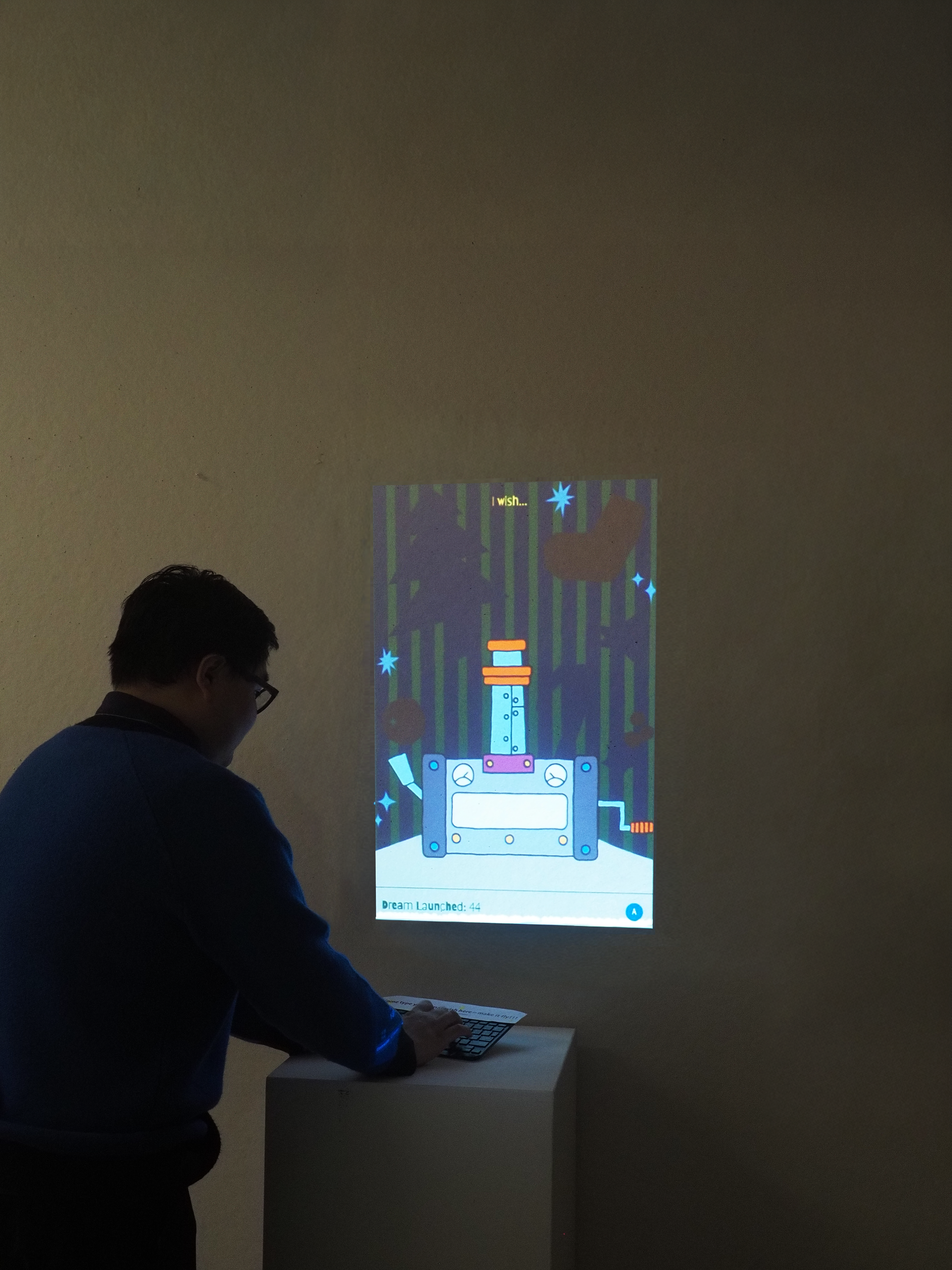 I placed a keyboard in front of the projection so that when the audience types while facing the screen, the text they enter appears to fly into the monitor.